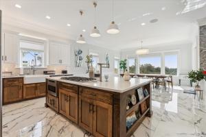 a kitchen with white walls and a large island at 8 Sea Front, Oceanfront Estate, Pool, Game Room, Elevator in Hilton Head Island