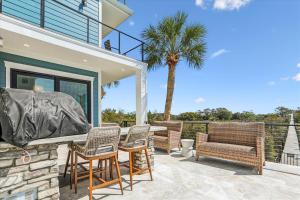 a patio with a table and chairs and a palm tree at 8 Sea Front, Oceanfront Estate, Pool, Game Room, Elevator in Hilton Head Island