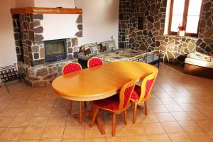 una mesa de madera y sillas en una habitación con chimenea en Penzion U Grobiana en Lenora