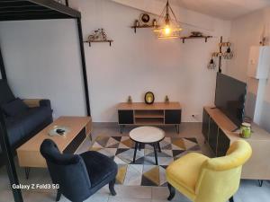 a living room with a couch and a table and chairs at Petite maison cosy in Albi