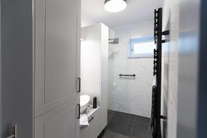 a white bathroom with a toilet and a shower at Hóvirág Apartman in Hódmezővásárhely