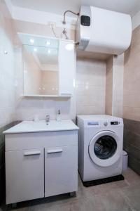 a bathroom with a washing machine and a sink at APARTMANI EMA in Zadar