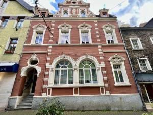 a red brick building with a clock tower on it at VonMos City Apartments in Traben-Trarbach