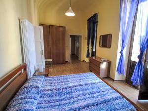 a bedroom with a bed with a blue blanket on it at Apartment Roma by Interhome in Porto Valtravaglia