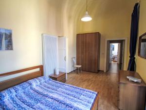a bedroom with a bed with a blue blanket on it at Apartment Roma by Interhome in Porto Valtravaglia
