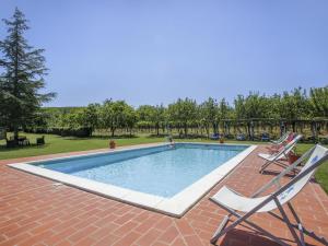 una piscina con due sedie a sdraio accanto di Apartment Fattoria Petraglia - Padronale by Interhome a Monteriggioni