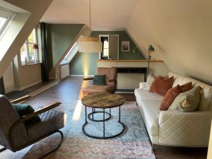a living room with a white couch and a table at Ferienapartment Am Urwald in Zetel