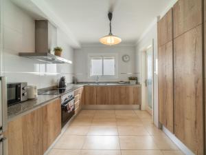 Una cocina grande con gabinetes de madera y fregadero. en Apartment Mariners 4 by Interhome, en Alcudia