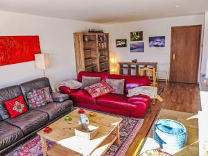 Una sala de estar con un sofá rojo y una mesa de café. en Chalet Chalet Aglaia by Interhome, en Bluche