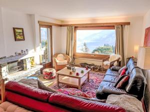 una sala de estar con un sofá y una mesa en Chalet Chalet Aglaia by Interhome, en Bluche