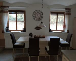 a kitchen with a table and chairs and a clock on the wall at Ferienwohnung Zur Flomborner Wutz in Flomborn