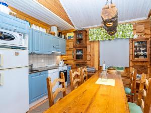 eine Küche mit Holztisch und Kühlschrank in der Unterkunft Holiday Home Rukaniemen kontio by Interhome in Ruka + 31 Fotos