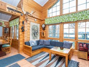 ein Wohnzimmer mit einem blauen Sofa und einem Tisch in der Unterkunft Holiday Home Rukaniemen kontio by Interhome in Ruka