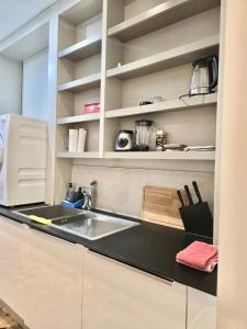 a kitchen with a sink and white cabinets at Marianne 1 in Brussels