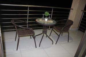 a table and two chairs on a balcony at Phendulani Lodge & Park in Calcutta