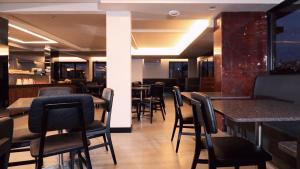 a restaurant with black chairs and tables and a bar at Ingleses Park Hotel in Florianópolis