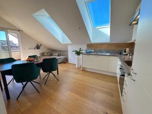a kitchen and dining room with a table and chairs at "EIGHT" Premium Apartments Seekirchen, charmante 3-Zi-Dachgeschoss-Wohnung mit Balkon in Seekirchen am Wallersee