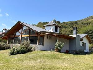 una casa bianca con una collina sullo sfondo di Fincas del Faldeo a Villa General Belgrano