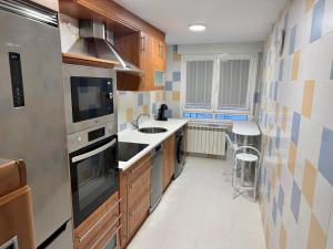 a kitchen with a sink and a stove at Encanto del Norte in Villarcayo