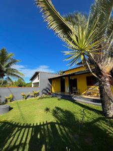 a house with a palm tree in front of a yard at Refugio Brisa do Campo - IG - SOLAR DO CAMPO in Iguaba Grande