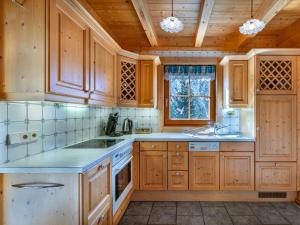 Una cocina con gabinetes de madera y encimera. en Holiday Home Karin by Interhome, en Heiligenblut 40 fotos más