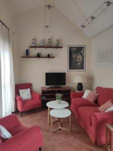 a living room with red couches and a tv at Comfortable penthouse in Islantilla golf in Lepe