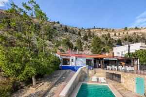 a house with a swimming pool next to a mountain at ALCALA DEL JUCAR, Casa rural Rio Tranquilo 1 -Piscina privada- in Tolosa