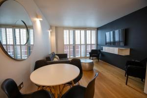 a living room with a table and chairs and a mirror at Luxury London Apartment in London