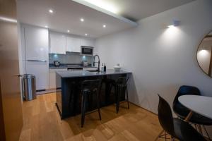 a kitchen with a counter and some chairs and a table at Luxury London Apartment in London