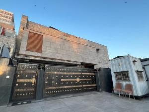 a building with a gate with two chairs in front of it at Avenue-3 Guest House in Islamabad