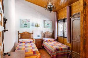 two beds in a small room with wooden ceilings at ALCALA DEL JUCAR, Casa rural Rio Tranquilo 1 -Piscina privada- in Tolosa +120 photos