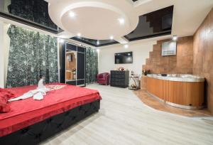 Alex Hotel on Budapeshtskaya في سانت بطرسبرغ: غرفة نوم مع سرير احمر كبير وحوض استحمام