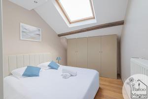 2 Betten in einem Schlafzimmer im Dachgeschoss mit Dachfenster in der Unterkunft Donald's Lodge - 5 minutes to Disneyland Paris in Magny-le-Hongre