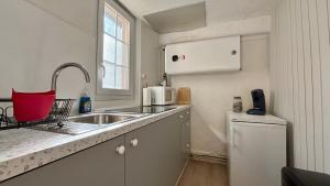 a small kitchen with a sink and a microwave at Le refuge autunois in Autun