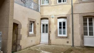 a building with two white doors and a balcony at Le refuge autunois in Autun +9 photos