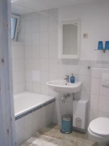 ein weißes Bad mit einem Waschbecken und einem WC in der Unterkunft Ferienwohnung Alte Brennerei in Brösa