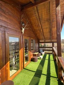 a room with green grass and wooden walls at Cabana AndreeaBanica in Moldoveneşti