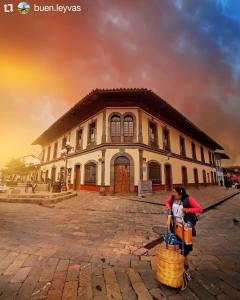 a woman is standing in front of a building at Hotel Villa De Las Flores in Zacatlán
