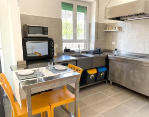 uma cozinha com mesa, cadeiras e uma TV em K-FOFO Apartment - Steps from Anzio Station, Beach & Town Center em Anzio mais 38 fotografias