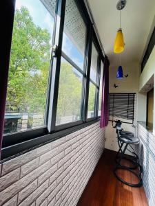 a room with a chair in front of a window at Miaoli Sanyi Travelling Homestay in Sanyi