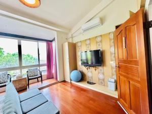 a living room with a couch and a tv at Miaoli Sanyi Travelling Homestay in Sanyi