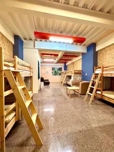 a room with several bunk beds and a couch at Miaoli Sanyi Travelling Homestay in Sanyi