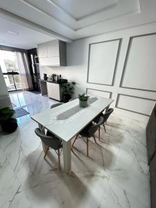 a dining room with a white table and chairs at Apartamento Piratuba Alegria, 104 in Piratuba