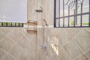 a shower stall in a bathroom with a window at Lake duluti serenity villas in Arusha +27 photos