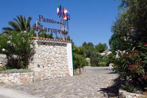 a sign for a resort on a stone wall at Villaggio Passo Dell'Arciprete in Vieste