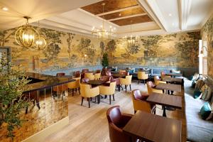 a restaurant with tables and chairs and a wall mural at The Kings Arms in Christchurch