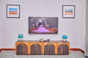 a living room with a tv on a wall at Lake duluti serenity villas in Arusha