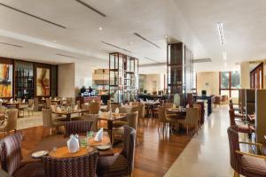 a restaurant with tables and chairs and a bar at Crowne Plaza - Dubai Jumeirah by IHG in Dubai