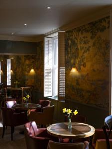 a restaurant with tables and chairs and a wall mural at The Kings Arms in Christchurch