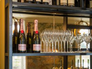 a shelf with bottles of wine and wine glasses at The Kings Arms in Christchurch
